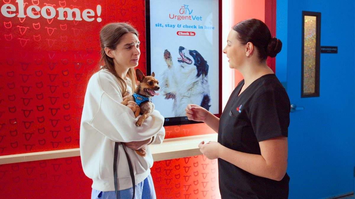A pet owner checking in at an UrgentVet kiosk